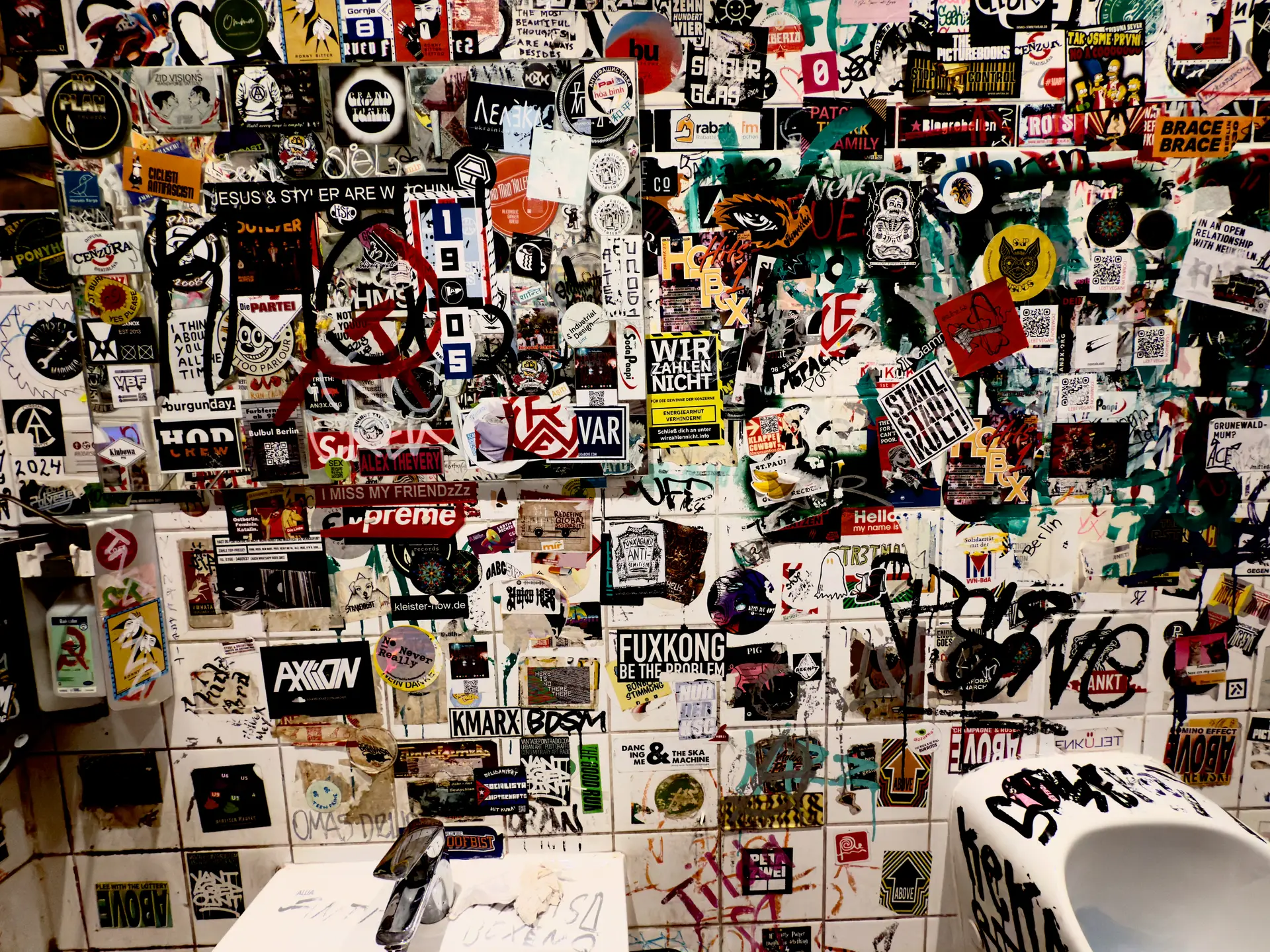 A wall of stickers in a toilet of a restaurant.